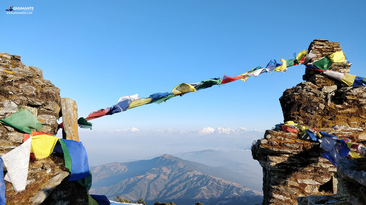 Prayers flag at the top and himalayan ranges in the backdrop.